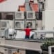 Man standing in front of several AC Units that need to be serviced on a hot summer day