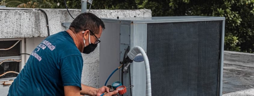 An HVAC technician working on an HVAC unit after swapping out a HEPA Filter for a Traditional Filter