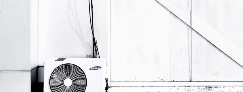 An clean HVAC unit on the outside of a building that's important for proper ventilation and indoor air quality.