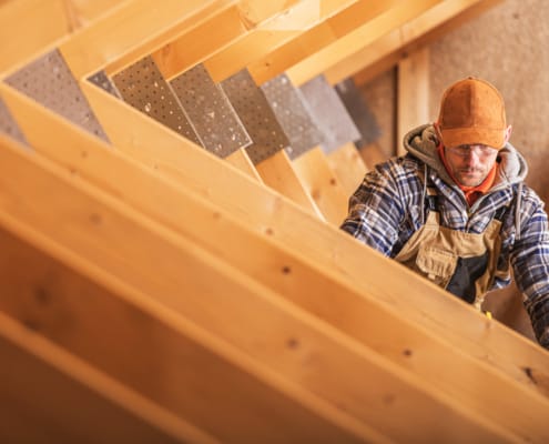 HVAC Specialist working in attic area on ducts
