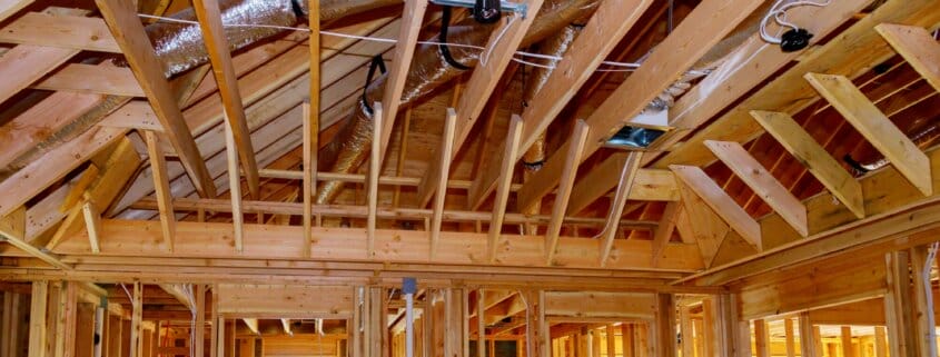 Installation under construction with wooden beams of HVAC tubing vents heating system on the roof,