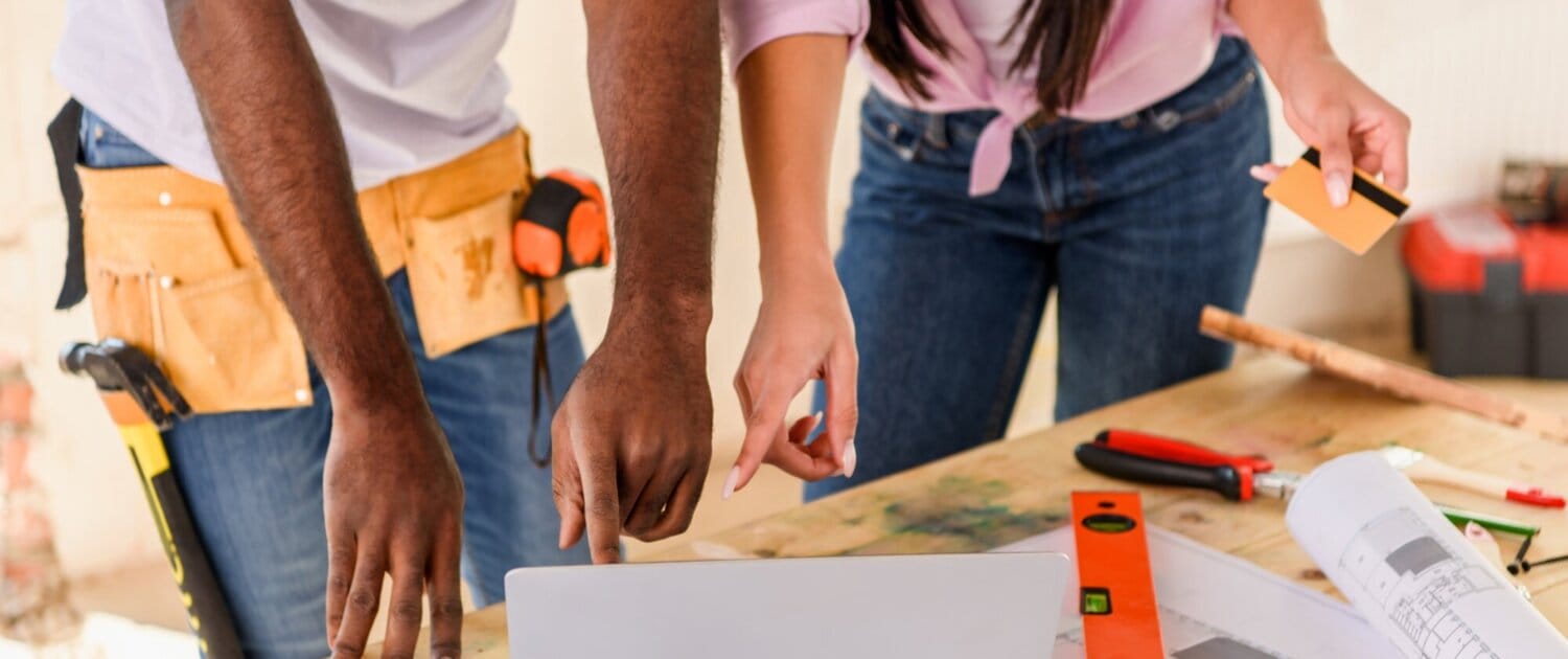 cropped shot of couple using laptop while making renovation of home