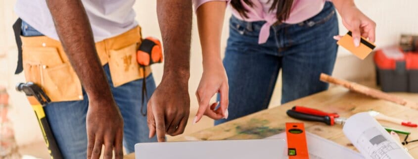 cropped shot of couple using laptop while making renovation of home