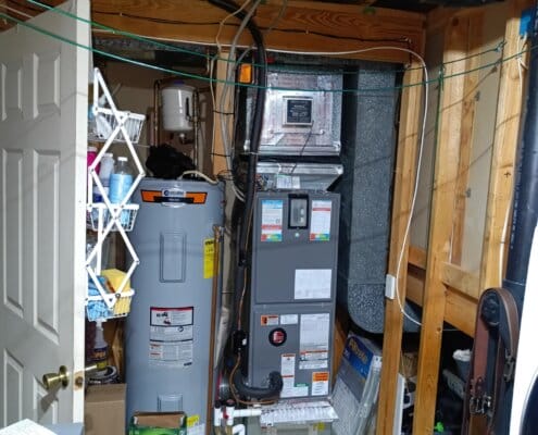 Basement utility room with Rheem HVAC system and water heater installed.