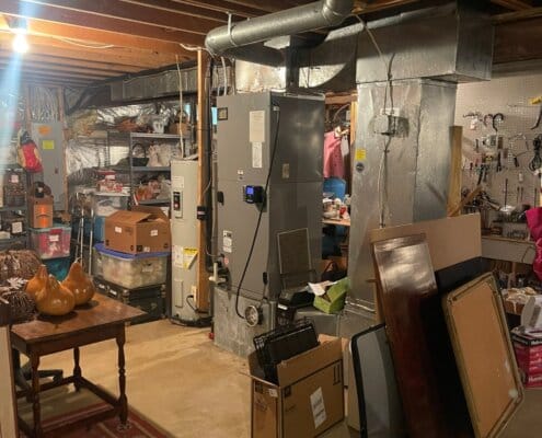 Basement with HVAC unit, water heater, and storage items