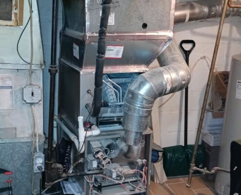 Exposed furnace system with ductwork and wiring inside a basement area.