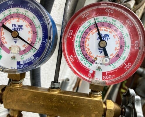 Two Yellow Jacket pressure gauges showing system readings for refrigerant levels.